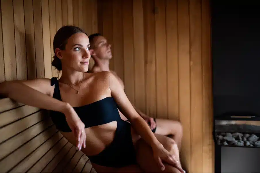 Sauna Extérieur Prix : Le Guide Complet 2026 pour Choisir le Meilleur Rapport Qualité-Prix 4 Les bienfaits du sauna sur le stress et le sommeil, avec une femme détendue profitant d’une séance de chaleur dans un sauna en bois.